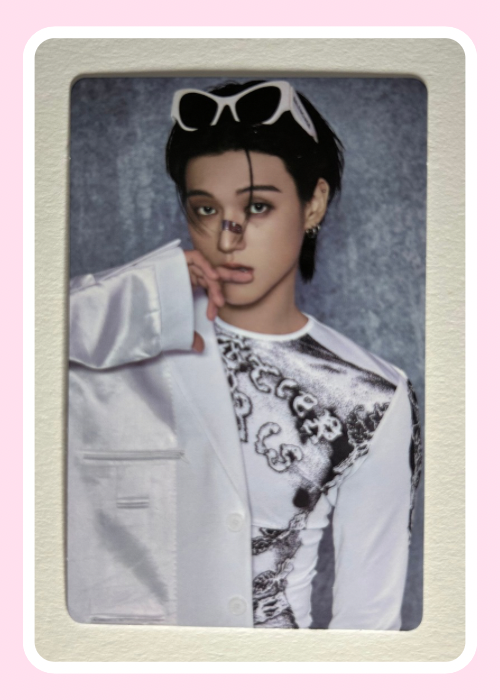 ATEEZ Wooyoung wearing a white outfit with black patterns and sunglasses on his head