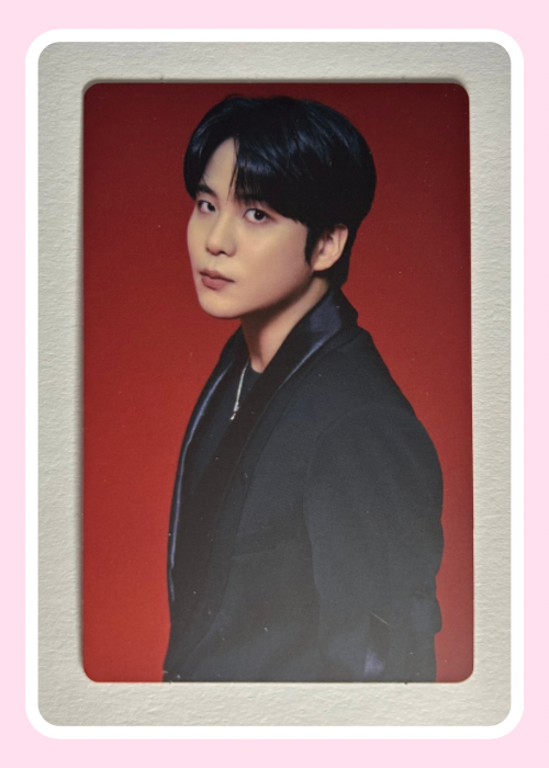 Jongho from Ateez wearing a dark jacket against a red background